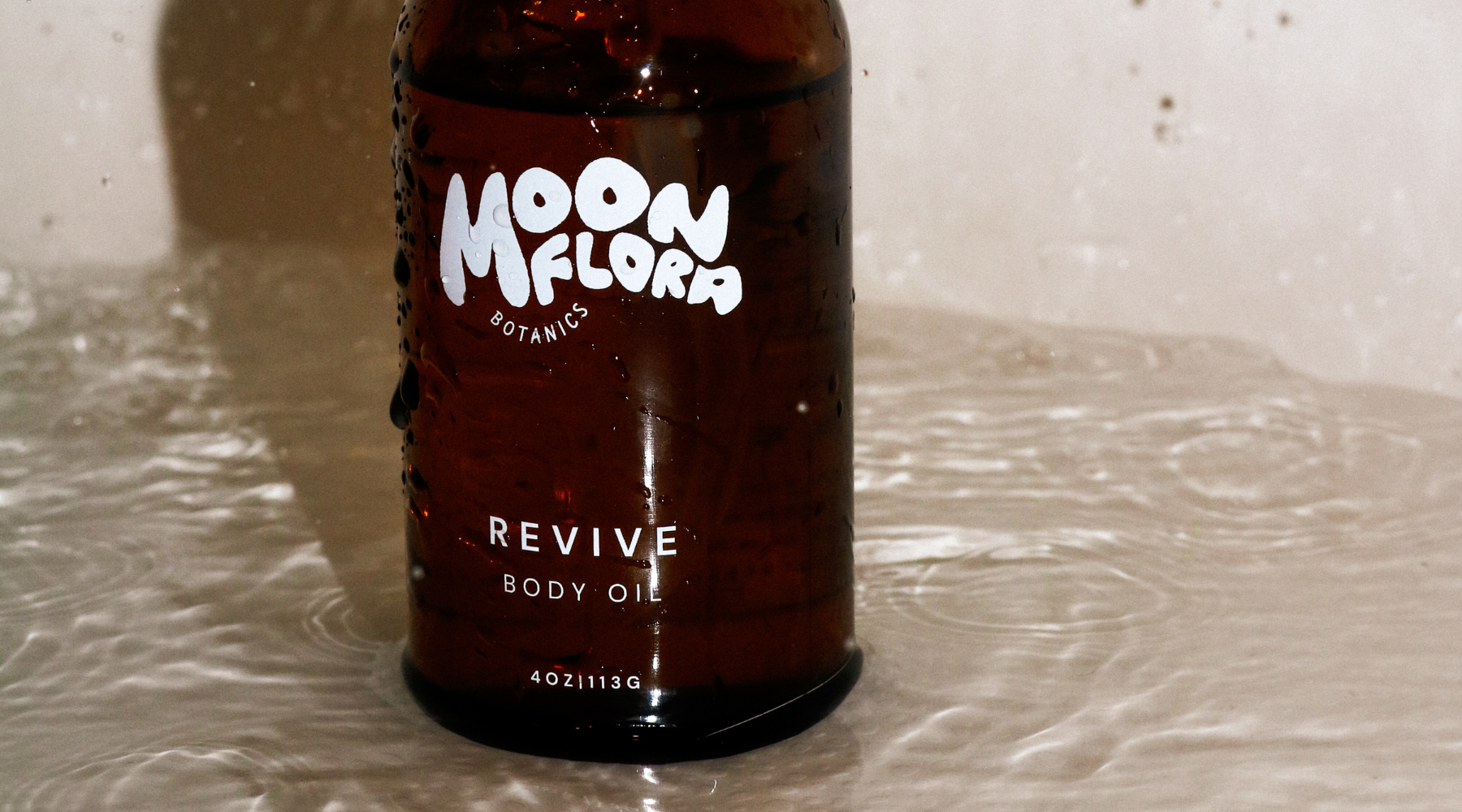 moonflora botanics revive body oil in bathtub with water for a blog about moisturizer for oily skin