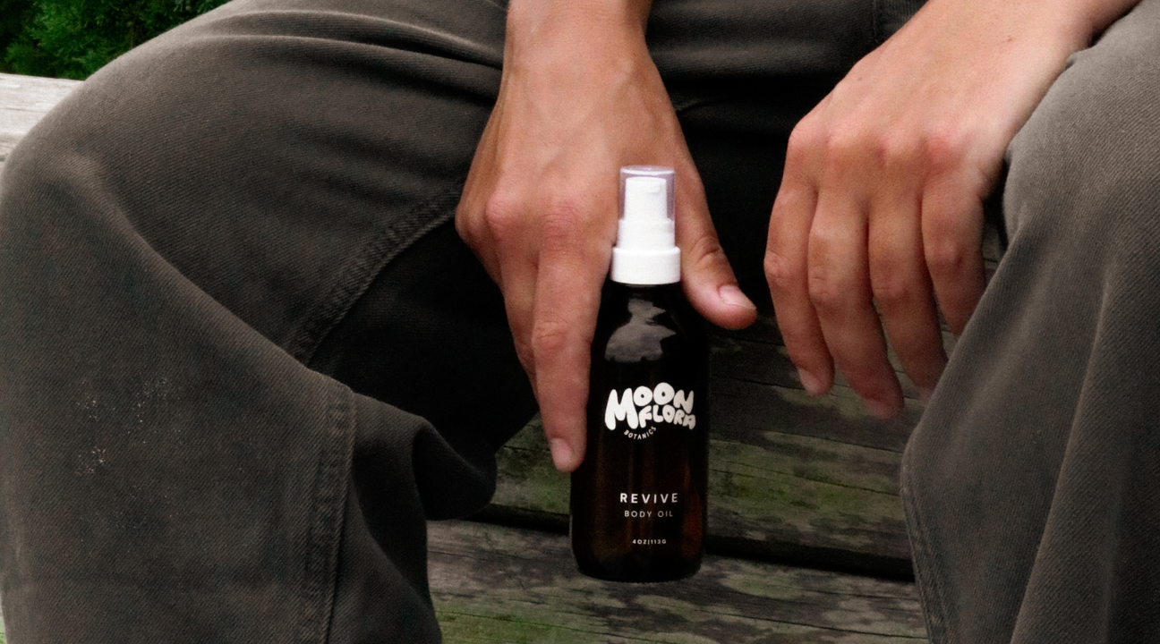 person holding bottle of moonflora botanics revive body oil for a blog about spring skincare tips 