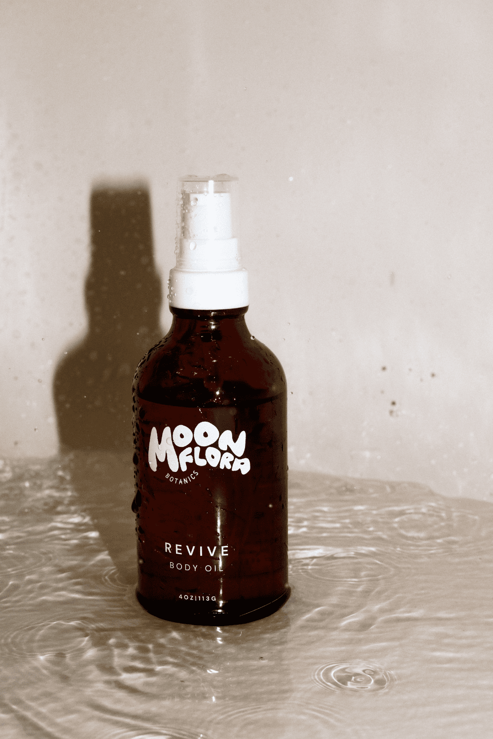 non toxic body oil with white spray nozzle in bathtub with water